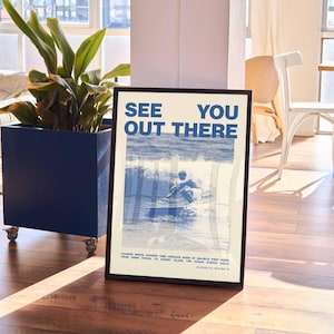 K&ouml;nnte beinhalten: Ein Poster mit einem blauen und wei&szlig;en Design, das einen Surfer auf einer Welle zeigt. Das Poster tr&auml;gt den Text "See You Out There" in blauen Buchstaben.