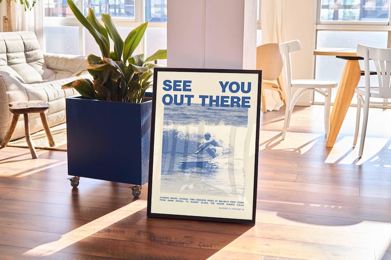 K&ouml;nnte beinhalten: Ein Poster mit einem blauen und wei&szlig;en Design, das einen Surfer auf einer Welle zeigt. Das Poster tr&auml;gt den Text "See You Out There" in blauen Buchstaben.