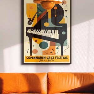 May include: A vintage-style poster for the Copenhagen Jazz Festival, featuring a black grand piano, a saxophone, and musical notes in a colorful abstract design. The poster is framed in black and has the text "Copenhagen Jazz Festival Jul 5 - Jul 14".