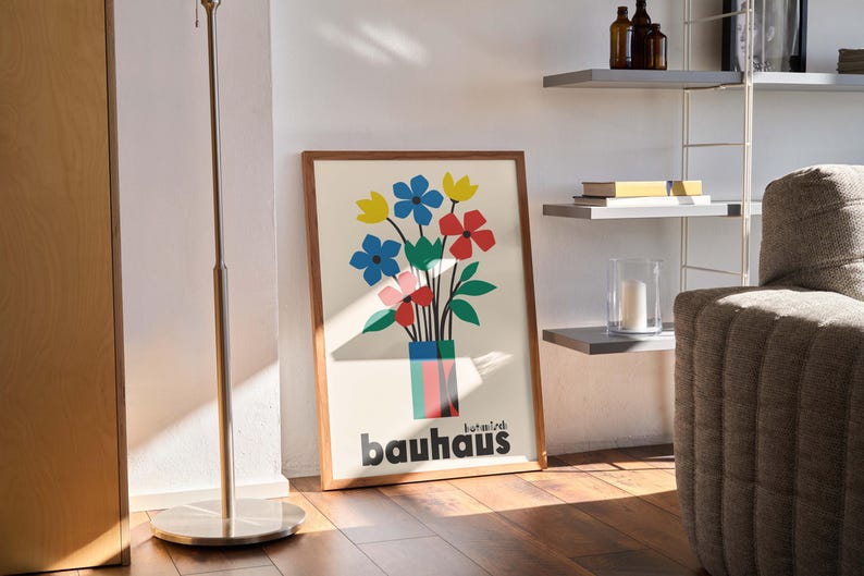 Pu&ograve; includere: Una stampa incorniciata di un arrangiamento floreale colorato in un vaso con la parola "bauhaus" stampata sotto. La stampa &egrave; su sfondo bianco e ha una cornice in legno.