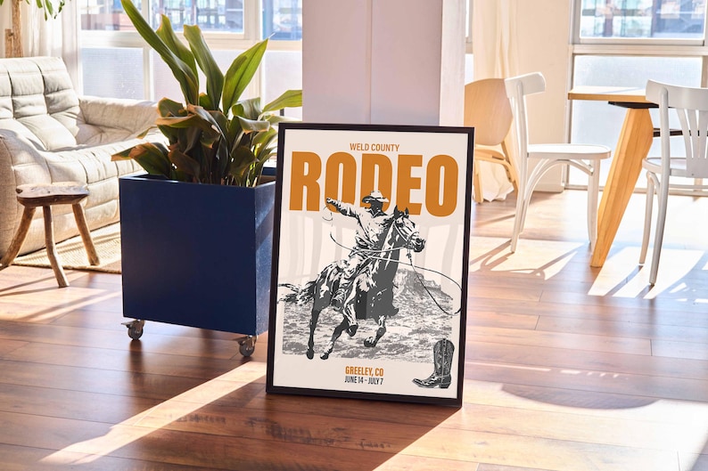 Pode incluir: Um p&ocirc;ster emoldurado em preto com uma ilustra&ccedil;&atilde;o de estilo vintage de um cowboy montando um cavalo. O p&ocirc;ster tem o texto "WELD COUNTY RODEO GREELEY, CO JUNE 14 - JULY 7" em laranja e preto.