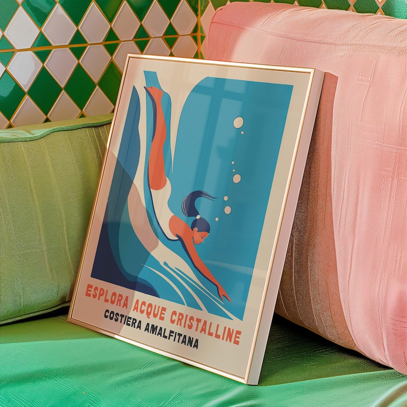 May include: A framed poster with a blue and white illustration of a person diving into water. The poster has the text "Esplora Acque Cristalline Costiera Amalfitana" in red and white.