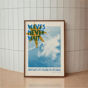 May include: Framed poster with a surfing theme. The poster features the text "WAVES NEVER WAIT" in blue and yellow, with an illustration of a surfer riding a wave. The bottom of the poster includes additional text. The frame is brown.