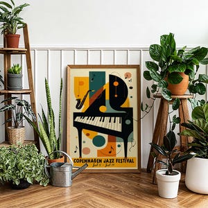 May include: A colorful poster with a stylized piano and saxophone, featuring the text "Copenhagen Jazz Festival" and the dates "July 8 - July 14". The poster is framed and hanging on a white wall, surrounded by potted plants.
