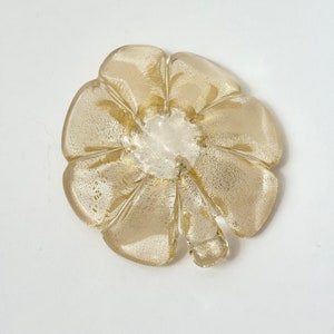 May include: A gold-colored glass flower-shaped dish with a textured surface.