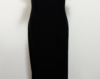 May include: A floor-length black velvet dress featuring thin spaghetti straps and a straight neckline adorned with a dense trim of black feathers. The garment has a fitted bodice and a long, straight skirt that extends to the floor.