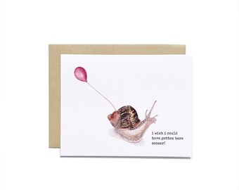 May include: A greeting card with a watercolor illustration of a snail with a pink balloon. The text on the card reads "I wish I could have gotten here sooner!"