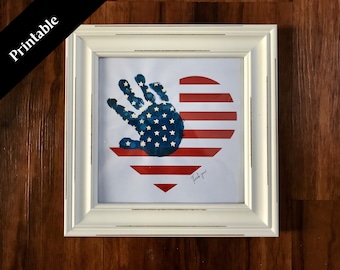 May include: A framed print of a handprint in the shape of a heart with the American flag design. The handprint is blue with white stars and the heart is red and white stripes. The print says "Thank you" at the bottom.