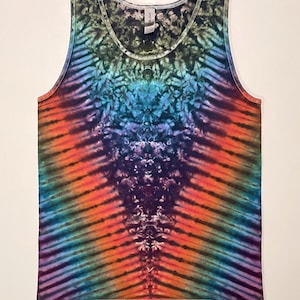 Puede incluir: Camiseta sin mangas teñida con efecto tie-dye en una vibrante gama de colores, incluyendo naranja, azul, morado y verde. La camiseta presenta un cuello redondo y un patrón de rayas verticales, creando un efecto psicodélico. La tela parece suave y ligera.