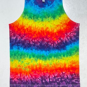 Könnte beinhalten: Regenbogen-Batik-Tanktop mit einem Farbschema aus dunkelviolett, blau, grün, gelb, orange und rot. Das Tanktop ist aus weicher, bequemer Baumwolle.