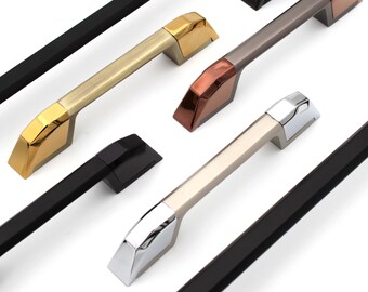 Peut inclure: Assortiment de poignées de porte de placard dans différentes finitions, notamment noir, or, argent et cuivre. Les poignées ont un design moderne et géométrique.