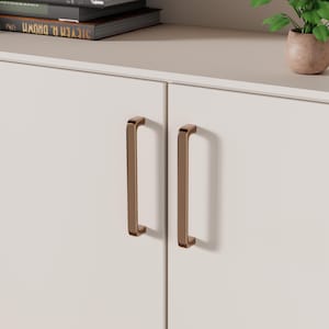 Könnte beinhalten: Nahaufnahme eines weißen Schranks mit zwei bronzefarbenen, rechteckigen Griffen. Die Griffe sind vertikal ausgerichtet und haben ein schlankes, modernes Design. Die Schranktüren sind geschlossen, die Griffe sind der Fokus.