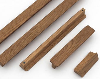 May include: A collection of wooden furniture components in various shapes and sizes. The pieces are a warm brown color, with visible wood grain. The components include long, rectangular strips and shorter, angled pieces, suggesting a DIY furniture project.