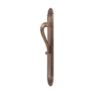 May include: A bronze-colored door handle with an ornate design. The handle features a curved grip and is mounted on a rectangular backplate with decorative edges. The overall style is vintage and elegant.