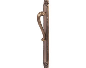 May include: A bronze-colored door handle with an ornate design. The handle features a curved grip and is mounted on a rectangular backplate with decorative edges. The overall style is vintage and elegant.