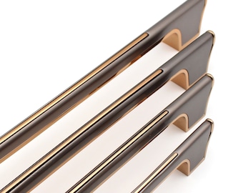 Peut inclure: Quatre poignées de porte de différentes tailles avec une finition nickel brossé et une ligne d'accent dorée. Les poignées ont un design contemporain.
