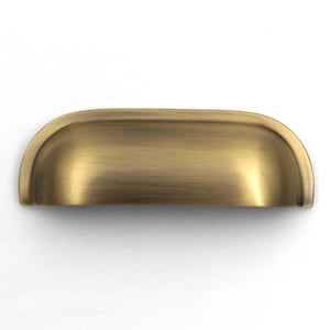 Könnte beinhalten: Ein halbkreisförmiger Muschelgriff mit gebürstetem Antikmessing-Finish. Das Beschlagteil hat ein glattes, geschwungenes Design mit einer vertieften Griffmulde und einem metallischen, goldbraunen Farbton mit feiner horizontaler Bürstung.