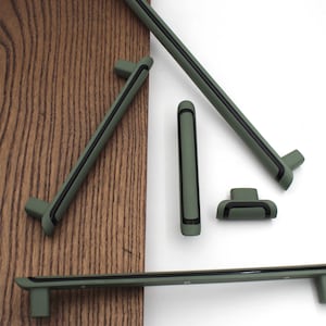 May include: Four green cabinet pulls with black trim. The pulls are in various sizes and shapes, including a long bar pull, a short bar pull, and a small knob.