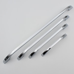 May include: Four chrome cabinet handles of varying lengths. The handles are curved and have a smooth, polished finish.