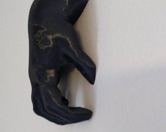 Creepy baby hand crawling on wall decoration