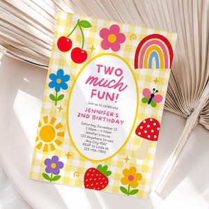 Op de afbeelding: Een rechthoekige verjaardagsuitnodiging met een geel-witte gingham achtergrond. In het midden staat een ovaal kader met de tekst 'TWO MUCH FUN! Join us to celebrate JENNIFER'S 2ND BIRTHDAY' en evenementdetails. De afbeeldingen bevatten kersen, bloemen, een regenboog, een vlinder, een zon en een paddenstoel.