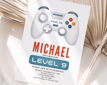 Może przedstawiać: Biała prostokątna karta zaproszenia z akwarelową ilustracją kontrolera do gier na górze z napisem GAME ON. Poniżej znajduje się tekst MICHAEL HAS UNLOCKED LEVEL 9, a następnie szczegóły wydarzenia, w tym data, godzina i adres.