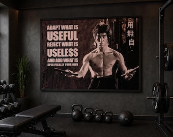 May include: A framed black and white poster featuring Bruce Lee with the text "ADAPT WHAT IS USEFUL, REJECT WHAT IS USELESS, AND ADD WHAT IS SPECIFICALLY YOUR OWN." The image is in a gym setting with weights, a bench, and kettlebells.