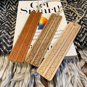 Wooden bookmark with a laser engraved woven braid design and suede leather tassel