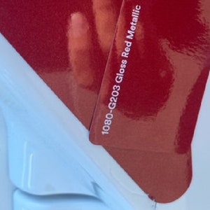 Puede incluir: Una muestra de pintura roja con el texto "1080-G203 Gloss Red Metallic".