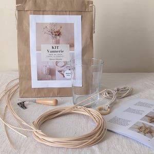Peut inclure: Un kit d'artisanat pour fabriquer un vase suspendu. Le kit comprend un sac en papier brun avec du texte imprimé, un verre transparent, une bobine de ficelle de couleur naturelle, un outil en bois et un livret d'instructions. Une corde beige avec un anneau en bois est également incluse.