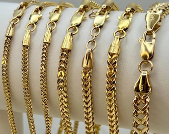 May include: Several gold-colored bracelets with various chain link designs are displayed. Each bracelet features a clasp for secure fastening. The bracelets are presented against a white background, highlighting their shiny, metallic appearance. The jewelry is likely made of gold.
