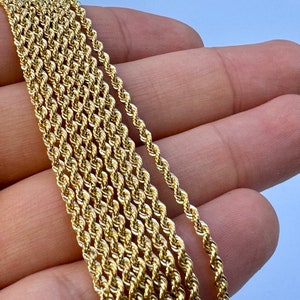 May include: A close-up of a gold rope chain necklace. The chain is made of multiple strands of twisted gold wire.