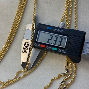 May include: Three gold rope chains with a close-up of a measuring tool showing a measurement of 2.33 mm.