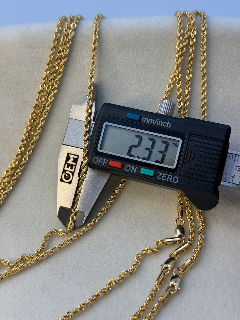 May include: Three gold rope chains with a close-up of a measuring tool showing a measurement of 2.33 mm.