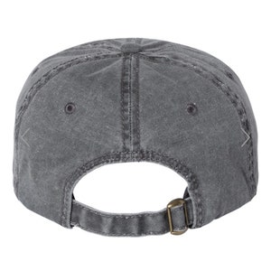 May include: A gray, washed cotton baseball cap with a brown adjustable buckle closure.