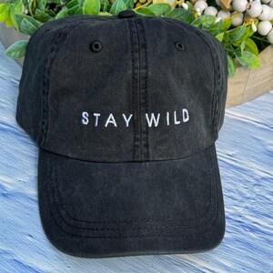 以下が含まれることがあります： 前面に「STAY WILD」という白い刺繍が施された黒い野球帽