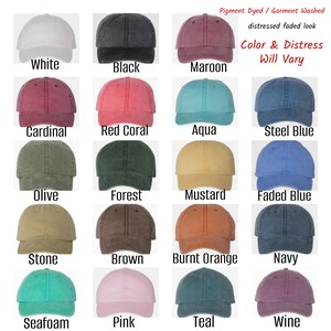 May include: A chart of 16 different colored baseball caps. The caps are pigment dyed and garment washed, with a distressed faded look. The colors include white, black, maroon, cardinal, red coral, aqua, steel blue, olive, forest, mustard, faded blue, stone, brown, burnt orange, navy, seafoam, pink, teal, and wine. The text "Pigment Dyed / Garment Washed distressed faded look Color & Distress Will Vary" is at the top of the chart.