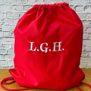 May include: Red drawstring bag with white embroidered initials "L.G.H."