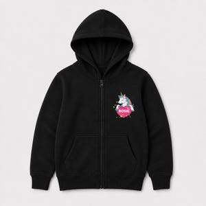May include: A black zip-up hoodie featuring a graphic on the left chest. The graphic depicts a white unicorn with a colorful mane and a gold horn, positioned above a pink heart containing the white text ROSIE, surrounded by small yellow stars.