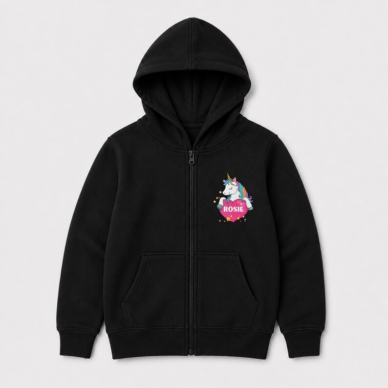 May include: A black zip-up hoodie featuring a graphic on the left chest. The graphic depicts a white unicorn with a colorful mane and a gold horn, positioned above a pink heart containing the white text ROSIE, surrounded by small yellow stars.