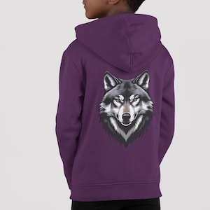Peut inclure: Un sweat à capuche violet avec un motif de tête de loup sur le dos. Le loup a des poils noirs, gris et blancs avec des yeux jaunes. Le sweat à capuche a une capuche et est de couleur violette unie.
