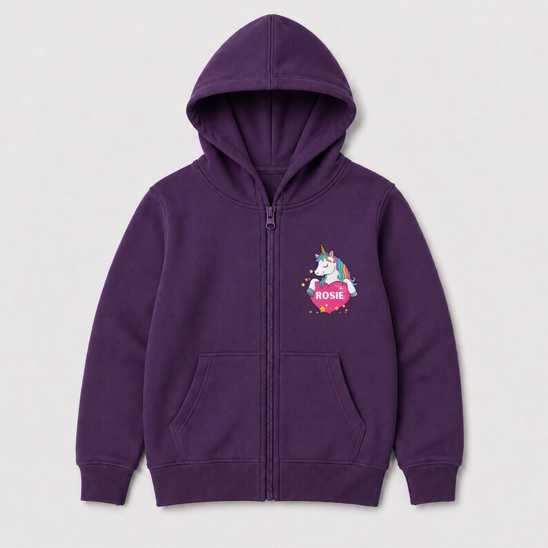 May include: A deep purple zip-up hoodie featuring a hood, long sleeves, and two front pockets. On the left chest, there is a graphic of a white unicorn with a colorful mane and a gold horn, positioned above a pink heart containing the name ROSIE.