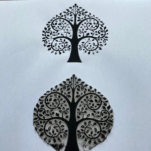 Puede incluir: Dos impresiones en tinta negra de un árbol estilizado con un tronco grueso y muchas ramas con hojas. El árbol está impreso en papel blanco.
