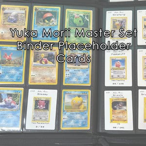 以下が含まれることがあります： 黒いバインダーにポケモンカードが詰まっています。カードは保護スリーブに入っており、様々なカラフルなイラストが描かれています。バインダーには「Yuka Morii Master Set Binder Placeholder Cards」と書かれています。