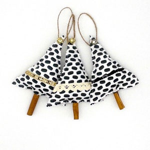 May include: Three black and white polka dot Christmas tree ornaments with cinnamon sticks and gold bells.