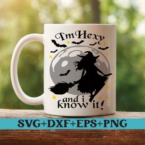 May include: White ceramic mug with a black silhouette of a witch flying on a broomstick in front of a full moon. The text "I'm Hexy and I know it!" is printed on the mug.