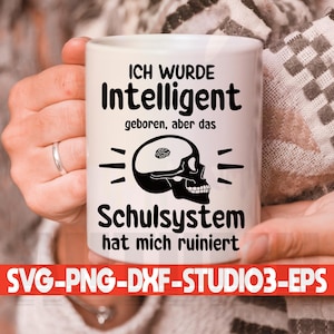 May include: White coffee mug with black text that reads "ICH WURDE Intelligent geboren, aber das Schulsystem hat mich ruiniert". The text is surrounded by a black skull with a brain inside.