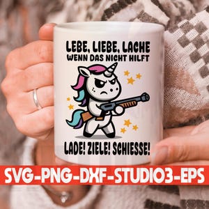 Könnte beinhalten: Weiße Keramiktasse mit einem bunten Comic-Einhorn, das eine Waffe hält. Der Text auf der Tasse lautet "LEBE, LIEBE, LACHE WENN DAS NICHT HILFT LADE! ZIELE! SCHIESSE!"