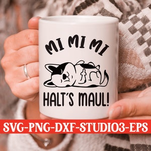 May include: White ceramic mug with a black and white illustration of a dog sleeping and the text "MI MI MI HALT'S MAUL!" printed on it.