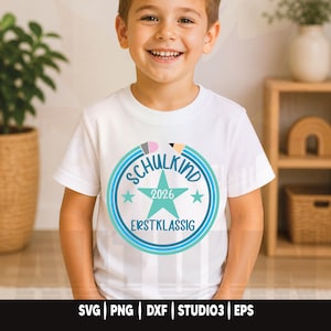 May include: A white t-shirt featuring a circular design with the words "SCHULKIND 2026 ERSTKLASSIG" in blue and teal. The design includes a star and pencil illustrations. The bottom of the image shows the text "SVG | PNG | DXF | STUDIO3 | EPS".